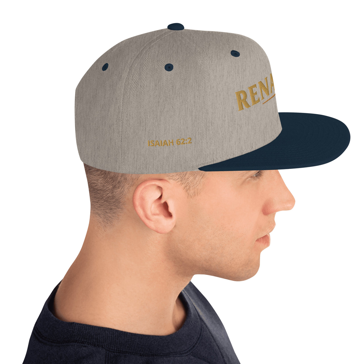 Male model wearing Renamed Classic Snapback in Heather Grey/Navy, right side embroidery showing “ISAIAH 62:2”