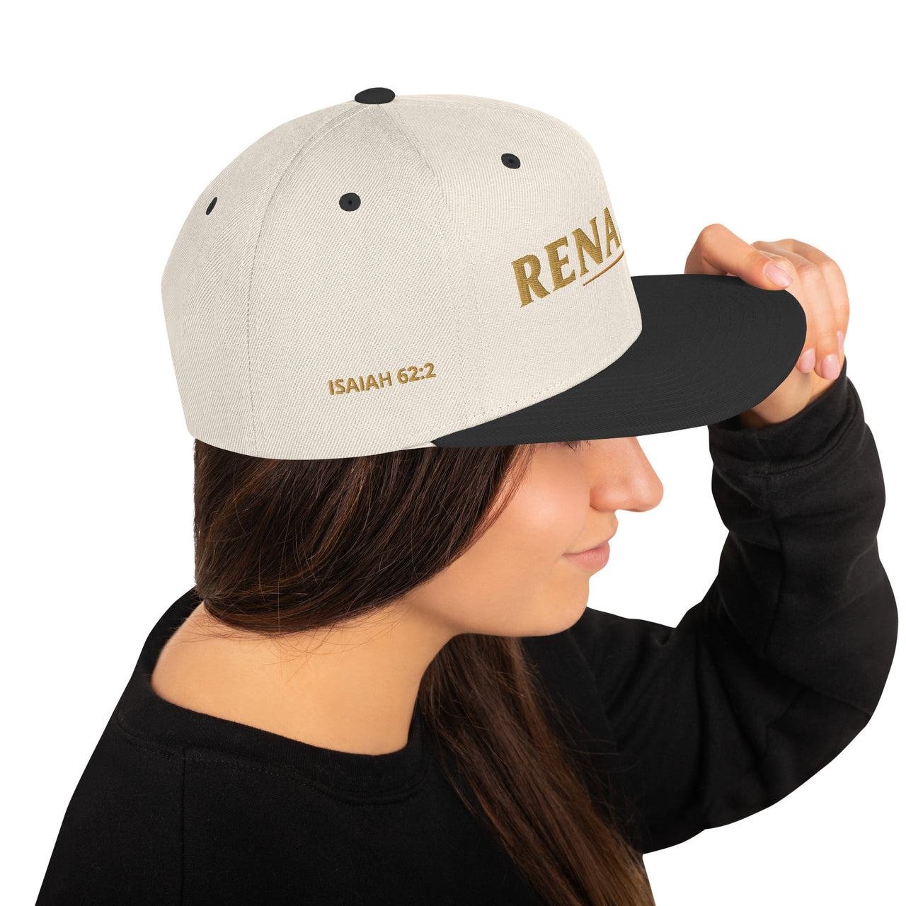 Female model wearing Renamed Classic Snapback in Natural/Black, right side embroidery showing “ISAIAH 62:2”