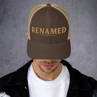 Male model wearing Renamed Trucker Cap in Brown/Khaki, angled front view showing embroidered design
