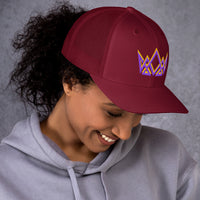 Woman in cranberry Royalty trucker hat – angled front view with stitched purple and gold embroidered crown