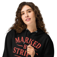 Close-up of woman wearing black Christian hoodie – red Marked by Stripes logo on chest