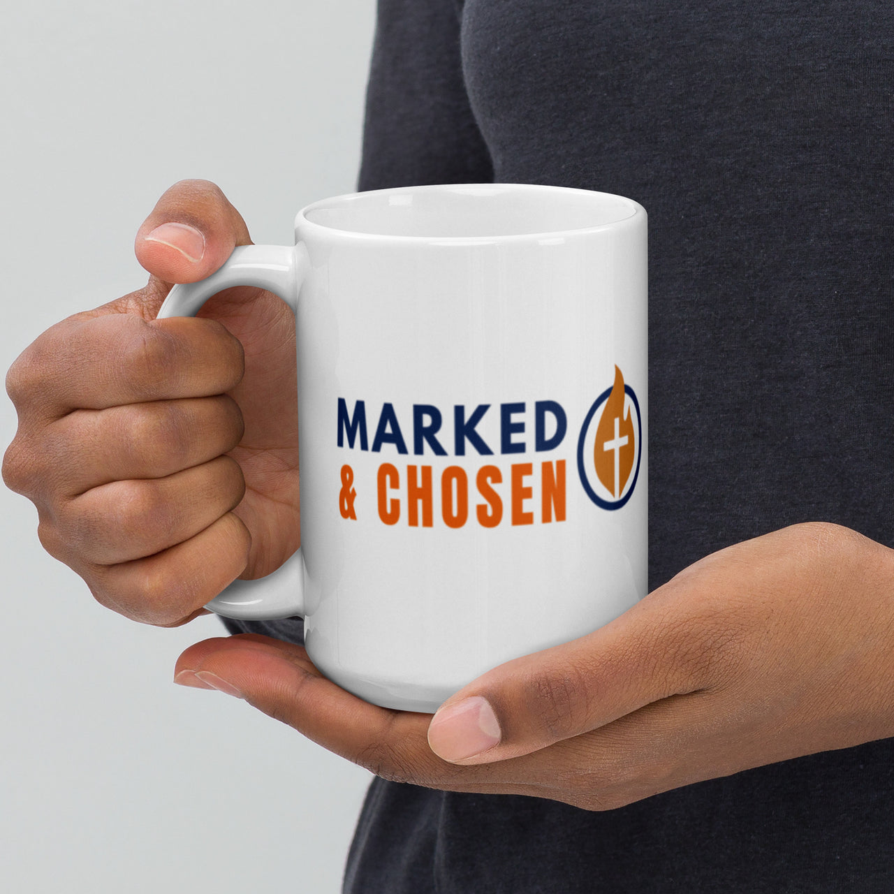 Model holding 15oz Marked & Chosen mug – white glossy finish with bold Christian logo