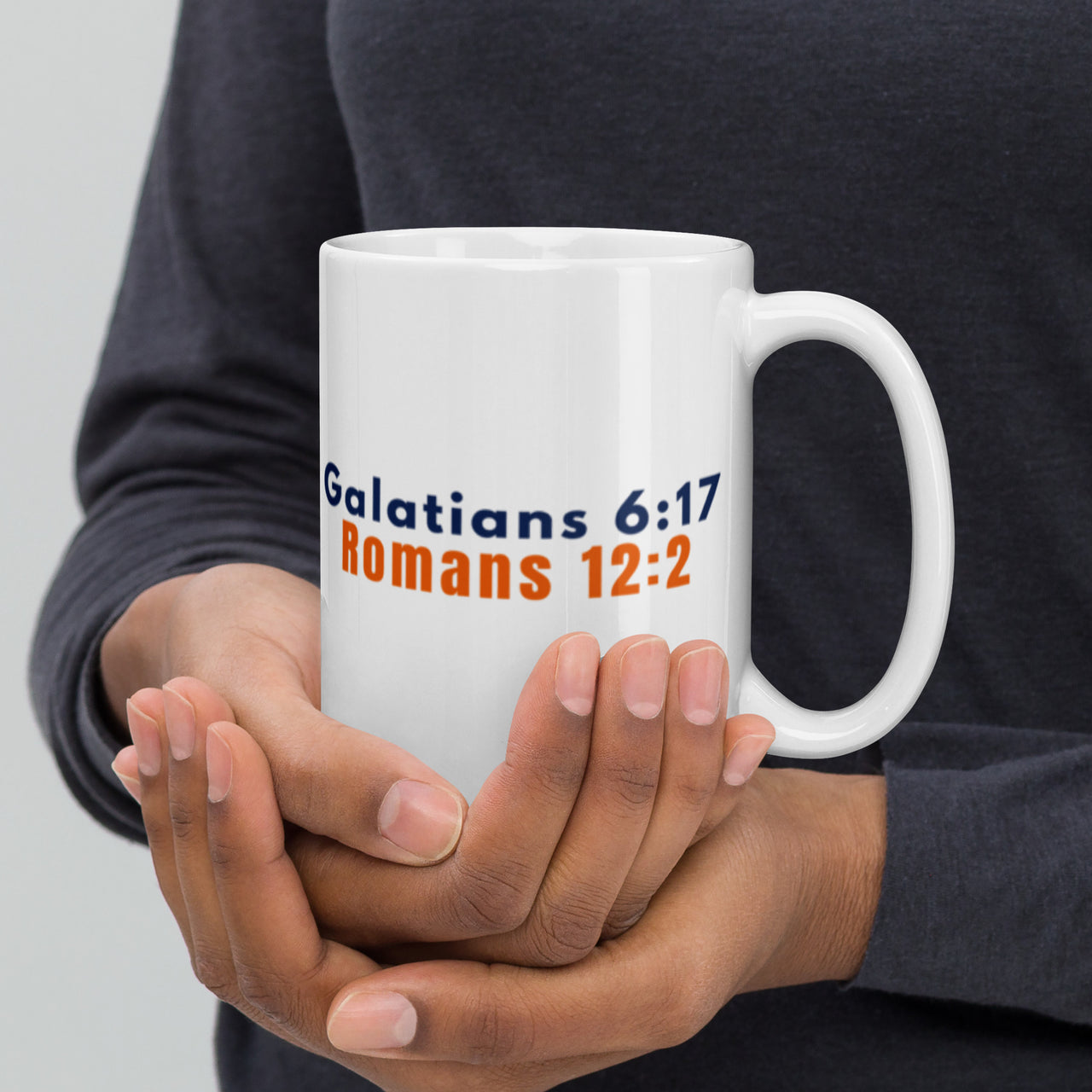 Model showing 15oz scripture mug – featuring Romans 12:2 and Galatians 6:17 verses on glossy ceramic